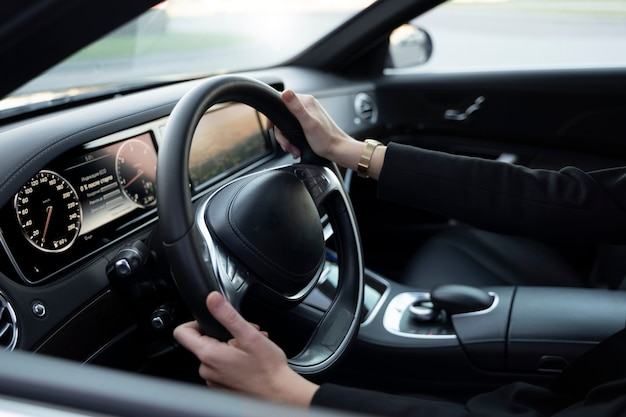 Driver adjusting the steering wheel inside a car